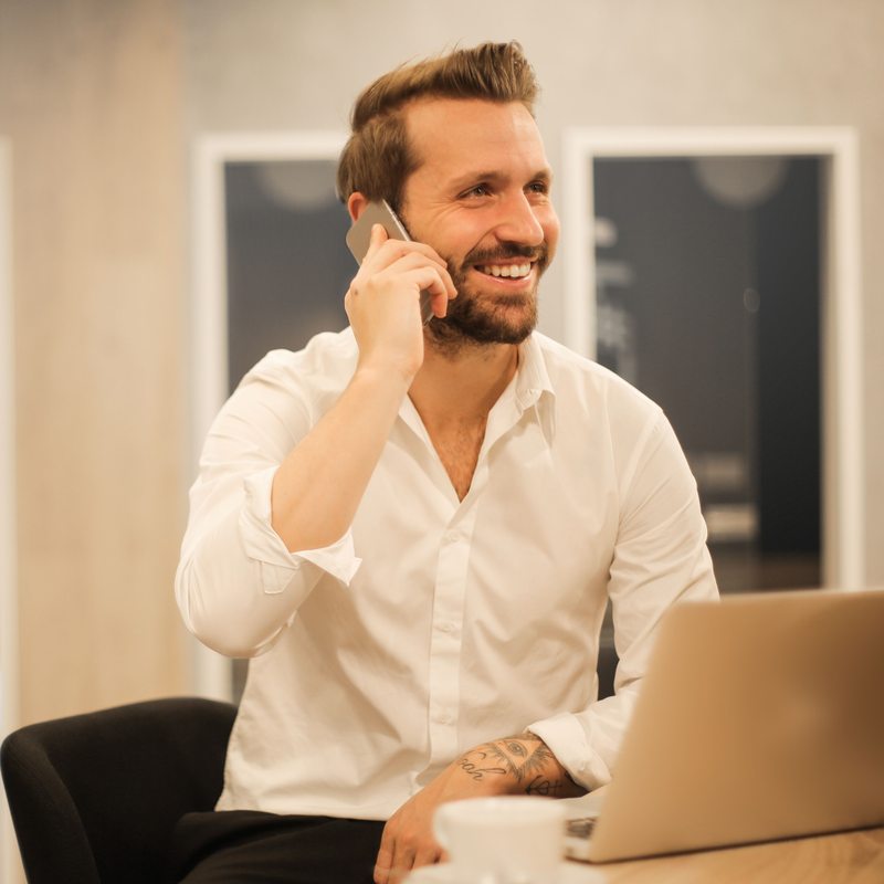 Business owner smiling on the phone at his desk
